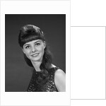 1960s portrait of smiling young woman in sequin dress looking at camera by Anonymous