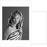 1960s portrait woman wrapped in striped sheet with seductive expression on face looking at camera by Anonymous