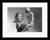 1960s smiling blond woman looking at camera shaking noise makers in her hands wear ruffled halter top by Anonymous