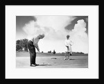 1960s older couple on golfing green man putting by Anonymous