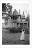 1970s woman in victorian costume standing on front lawn of large abandoned haunted victorian home by Anonymous