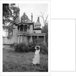 1970s woman in victorian costume standing on front lawn of large abandoned haunted victorian home by Anonymous