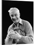 1920s smiling man marking golf club scorecard looking at camera by Anonymous