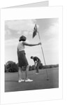 1970s couple playing golf man putting woman holding flag by Anonymous