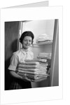1960s woman holding laundry folded towels by linen closet looking at camera by Anonymous