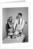 1950s satisfied amused smiling couple husband wife in kitchen cooking together by Anonymous