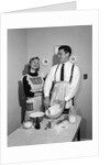 1950s satisfied amused smiling couple husband wife in kitchen cooking together by Anonymous