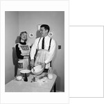 1950s satisfied amused smiling couple husband wife in kitchen cooking together by Anonymous