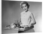 1950s woman looking at camera smiling holding platter of hors d'oeuvres snacks by Anonymous