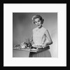 1950s woman looking at camera smiling holding platter of hors d'oeuvres snacks by Anonymous
