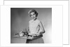 1950s woman looking at camera smiling holding platter of hors d'oeuvres snacks by Anonymous