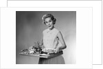 1950s woman looking at camera smiling holding platter of hors d'oeuvres snacks by Anonymous