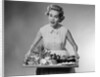 1950s woman looking at camera speaking holding platter of hors d'oeuvres snacks by Anonymous