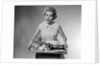 1950s woman looking at camera speaking holding platter of hors d'oeuvres snacks by Anonymous