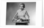 1950s woman looking at camera speaking holding platter of hors d'oeuvres snacks by Anonymous