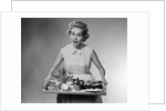 1950s woman looking at camera speaking holding platter of hors d'oeuvres snacks by Anonymous