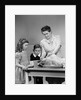 1940s mother son daughter in kitchen stuffing turkey for thanksgiving dinner by Anonymous