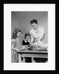 1940s mother son daughter in kitchen stuffing turkey for thanksgiving dinner by Anonymous