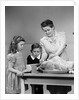1940s mother son daughter in kitchen stuffing turkey for thanksgiving dinner by Anonymous