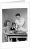 1940s mother son daughter in kitchen stuffing turkey for thanksgiving dinner by Anonymous