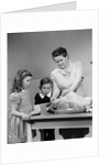 1940s mother son daughter in kitchen stuffing turkey for thanksgiving dinner by Anonymous