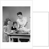 1940s mother son daughter in kitchen stuffing turkey for thanksgiving dinner by Anonymous