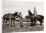 1930s 1940s couple in riding gear man riding horse woman standing by wooden fence by Anonymous