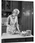 1930s woman in kitchen making strawberry shortcake by Anonymous