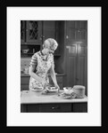 1930s woman in kitchen making strawberry shortcake by Anonymous