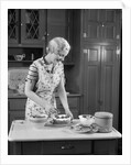 1930s woman in kitchen making strawberry shortcake by Anonymous