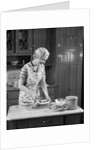 1930s woman in kitchen making strawberry shortcake by Anonymous