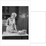 1930s woman in kitchen making strawberry shortcake by Anonymous