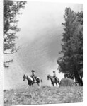1950s 1960s two men on horseback riding across field wearing cowboy hats by Anonymous