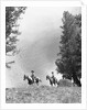 1950s 1960s two men on horseback riding across field wearing cowboy hats by Anonymous