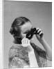 1930s 1940s woman putting on taking off black eye mask by Anonymous