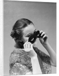 1930s 1940s woman putting on taking off black eye mask by Anonymous