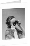 1930s 1940s woman putting on taking off black eye mask by Anonymous