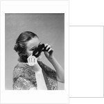 1930s 1940s woman putting on taking off black eye mask by Anonymous