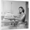 1960s satisfied woman homemaker holding folded laundry by Anonymous