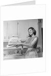 1960s satisfied woman homemaker holding folded laundry by Anonymous