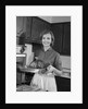 1960s smiling woman in kitchen taking roast out of oven looking at camera by Anonymous