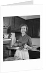 1960s smiling woman in kitchen taking roast out of oven looking at camera by Anonymous