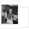 1960s smiling woman in kitchen taking roast out of oven looking at camera by Anonymous