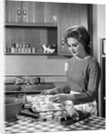 1960s woman housewife baking biscuits in kitchen by Anonymous
