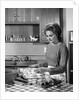 1960s woman housewife baking biscuits in kitchen by Anonymous