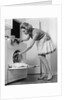 1970s woman removing laundry from dryer by Anonymous