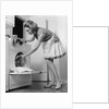 1970s woman removing laundry from dryer by Anonymous