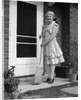 1940s smiling woman sweeping porch front door step with a broom looking at camera by Anonymous