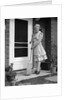 1940s smiling woman sweeping porch front door step with a broom looking at camera by Anonymous