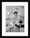 1950s smiling woman in kitchen holding grocery bag handbag wearing hat gloves looking at camera by Anonymous